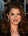 Debra Messing wearing her red hair in a curly long style