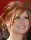 Debra Messing wearing her red hair in a simple updo