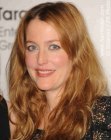 Gillian Anderson's long hair with layers and waves below the neckline
