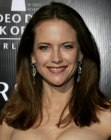 Kelly Preston wearing long blunt cut brown hair with a middle part
