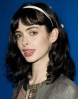 Krysten Ritter sporting a long hairstyle with waves and a head band