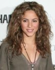 Shakira sporting a long hairstyle with waves and spiraled curls