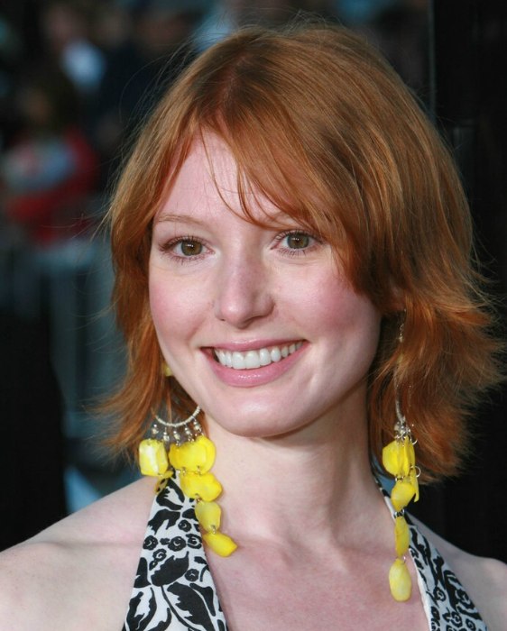 Alicia Witt's red hair cut to mid length in a shag style