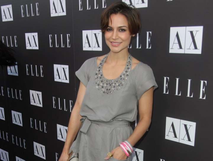 Samaire Armstrong wearing short hair and a gray dress with jewelled colar