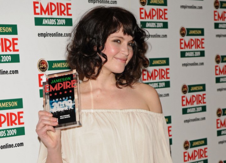 Gemma Arterton with her hair curled and wearing a bare shoulders dress