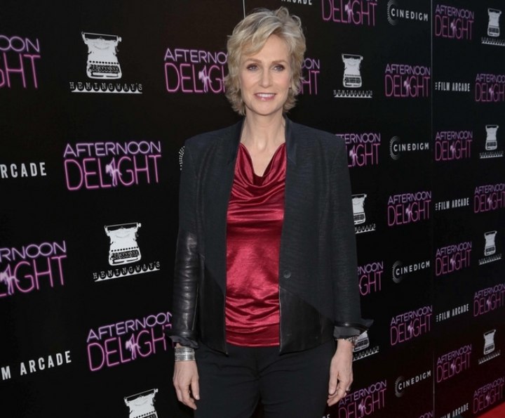 Jane Lynch wearing a shiny draped collar top