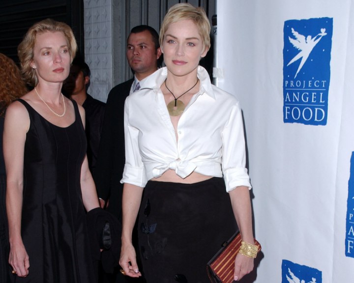 Sharon Stone with short hair and wearing her blouse knotted at her waist
