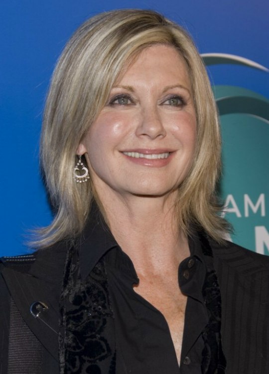 Olivia Newton John wearing her hair in a medium hairstyle 