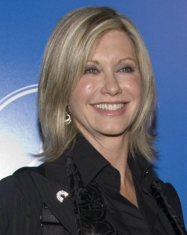 Olivia Newton John wearing her hair in a medium hairstyle 