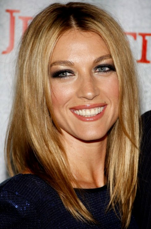 Natalie Zea with her long hair parted in the middle and 