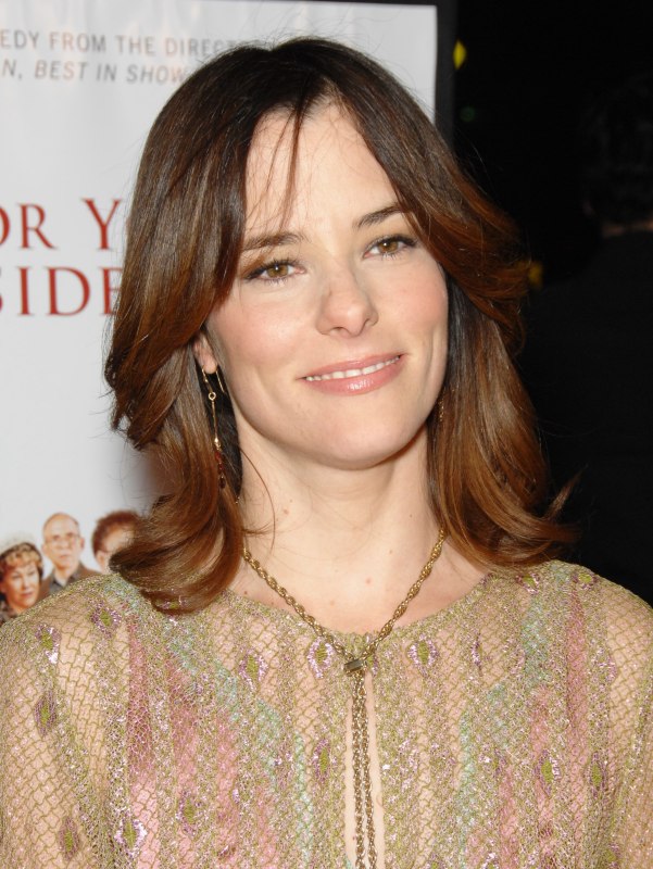 Parker Posey with long hair and bangs that hang along the 