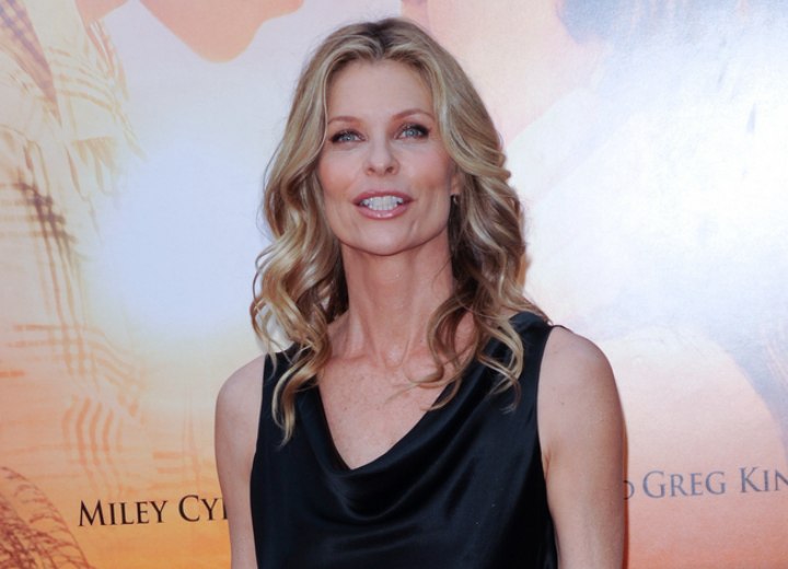 Kate Vernon wearing a silky black drape neck dress