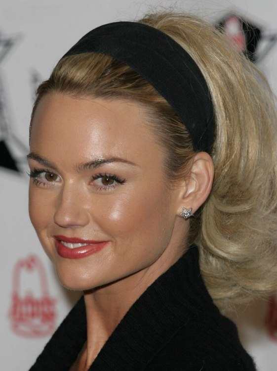 Kelly Carlson with her hair puffed up and wearing a headband
