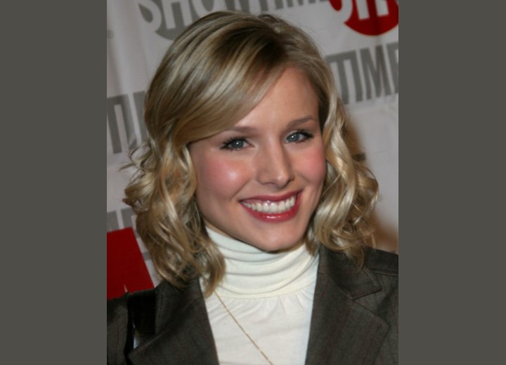 Kristen Bell wearing a white turtleneck and a pinstripe blazer