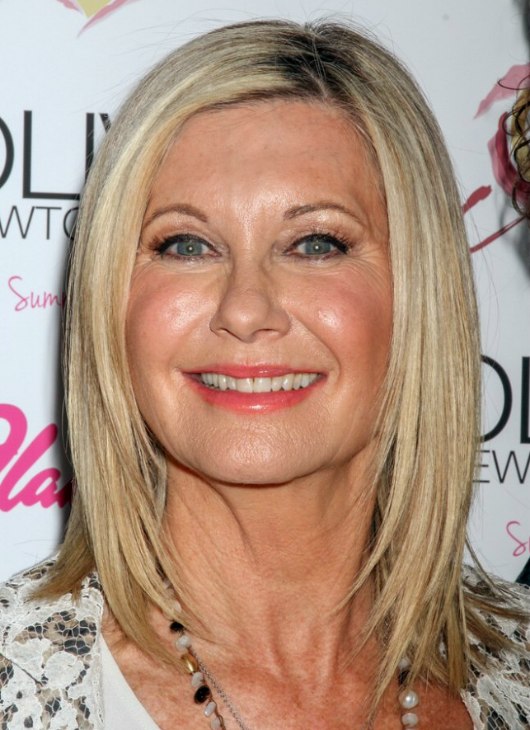 Olivia Newton John over age 65 and wearing her hair smooth and shoulder