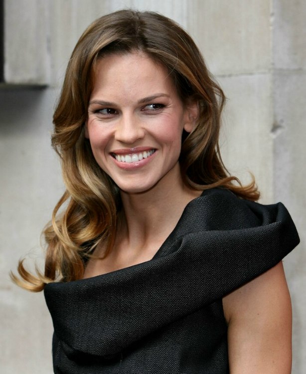 Hilary Swank with her long hair in curls that play around 