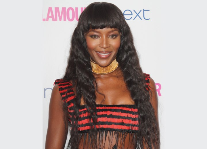 Naomi Campbell with her long hair styled in small waves