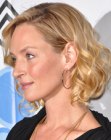 Uma Thurman wearing a medium length hairstyle with loose cylinder curls