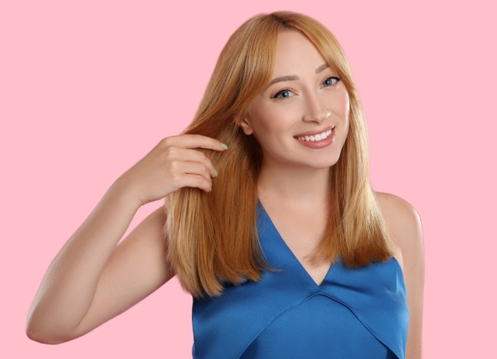 Blondes M&auml;dchen, das seine Haare auf Haarsch&auml;den &uuml;berpr&uuml;ft