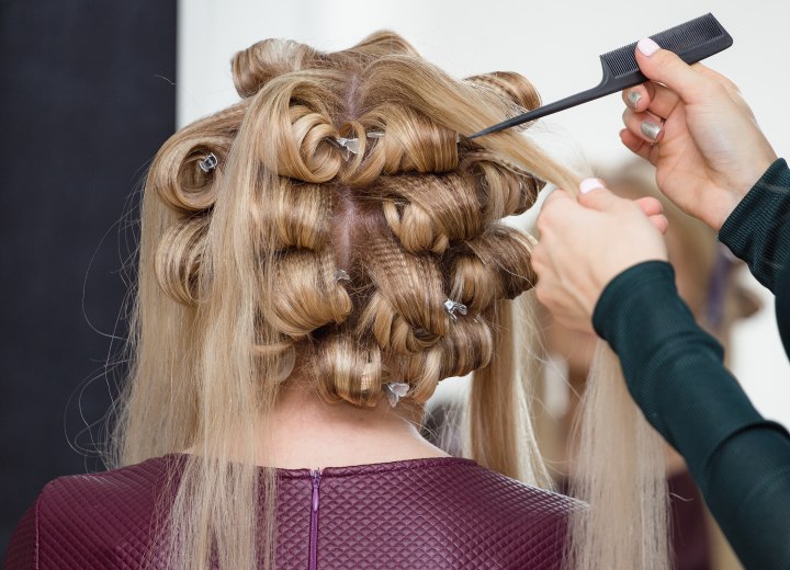 Estilista que está peinando el cabello recogido