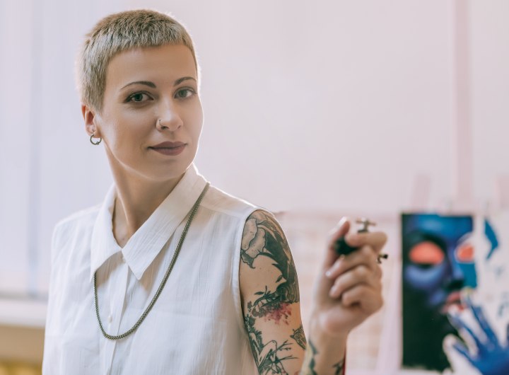 Female tattoo artist with very short hair