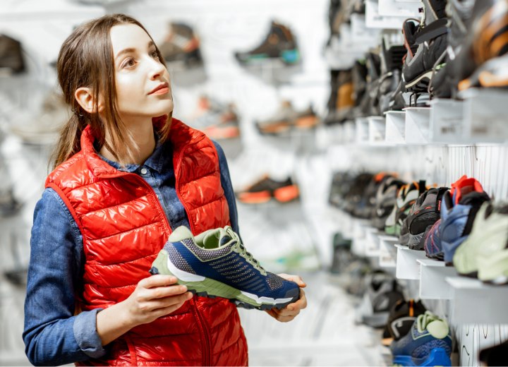 Young woman who is choosing new sneakers