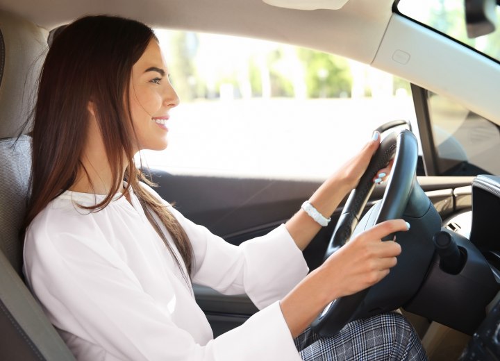 Femme aux cheveux longs et lâches conduisant une voiture