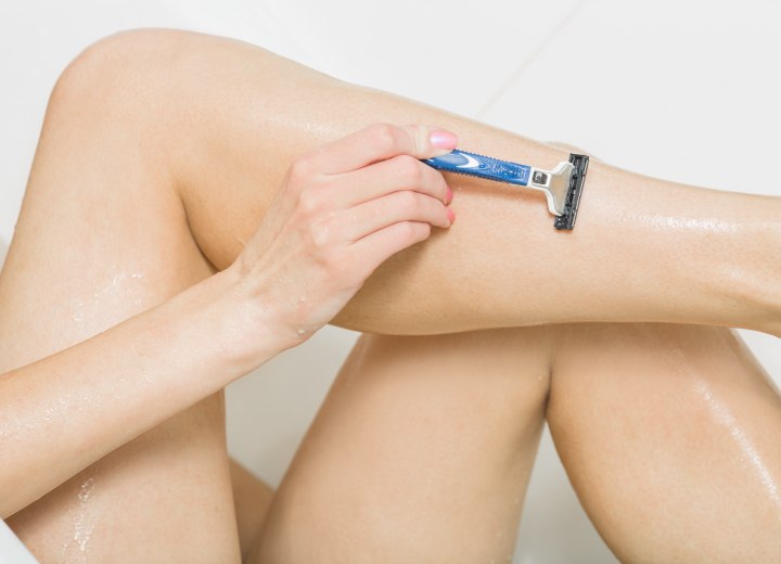 Woman while shaving her legs