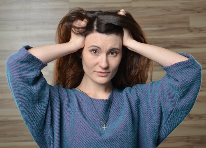 Woman touching her own scalp