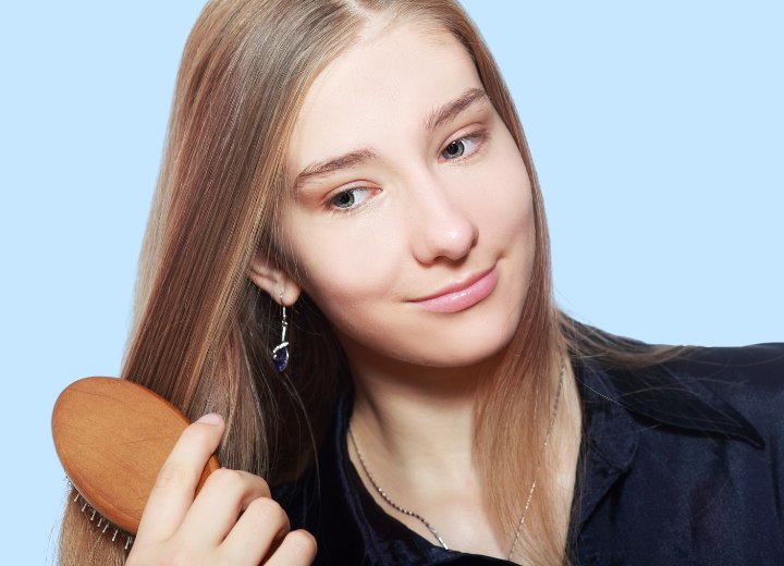 Young woman who is brushing her long hair