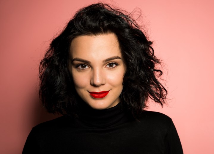 Woman with curly hair, wearing a turtleneck