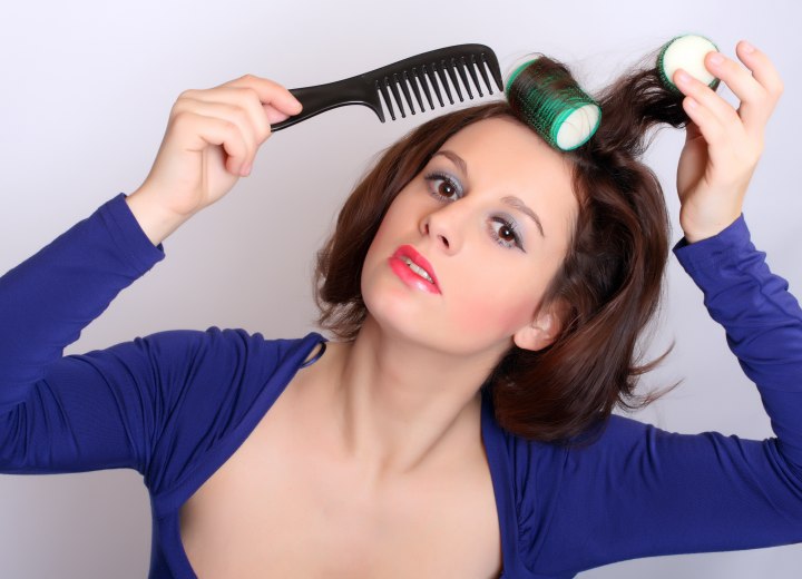 Woman who is putting curlers in her hair