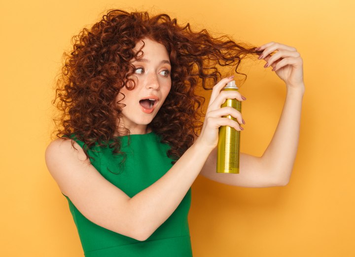 Woman with curly hair applying hairspray
