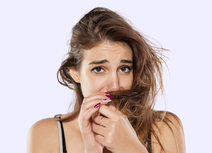 Woman who is smelling her own hair