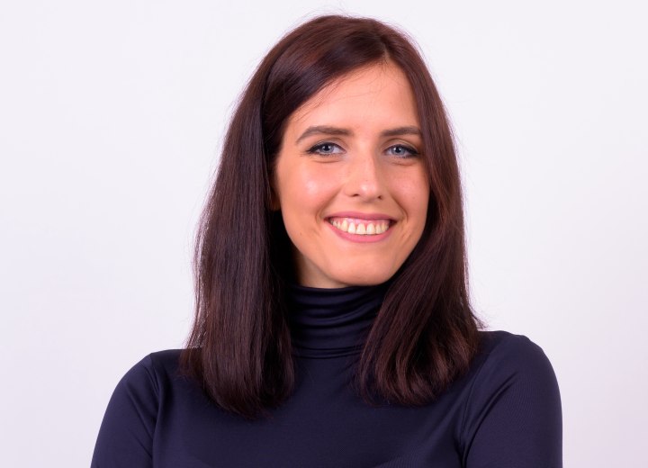 Young woman with brown hair wearing a shiny blue turtleneck