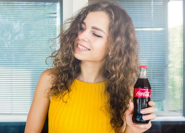 Woman with curly hair and Coca Cola