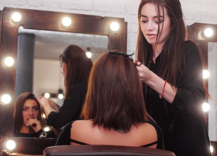 Hairdresser applying hair extensions