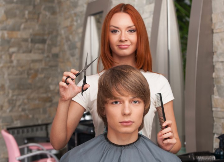 Female hairdresser who is cutting a man's hair