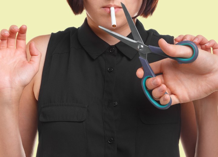 Scissors cutting a cigarette in half