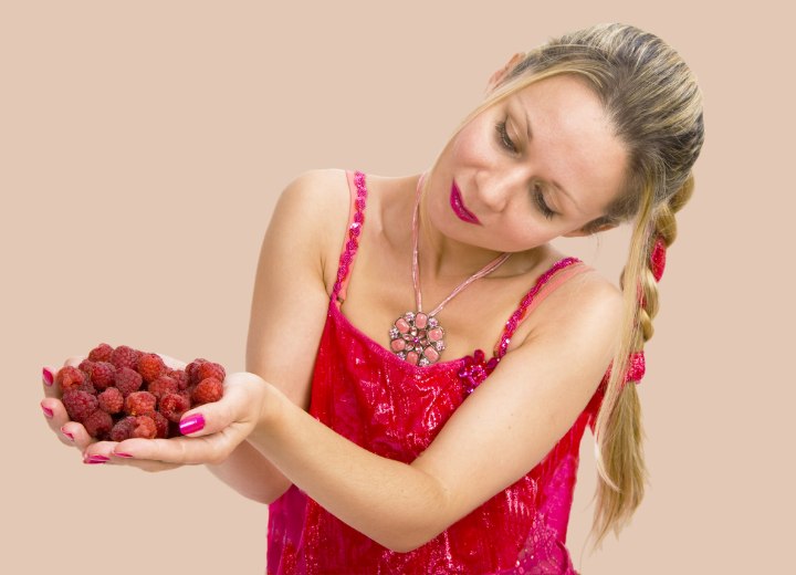 Woman who is holding raspberries in her hands