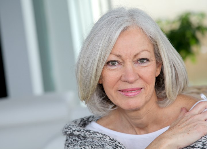 Blunt cut almost shoulder-length hairstyle for an older woman with gray hair