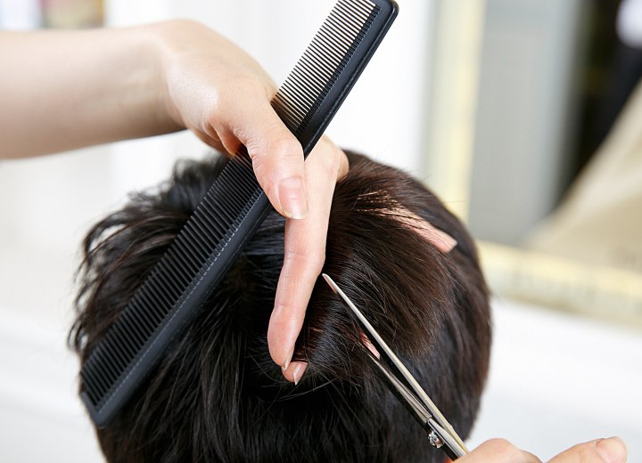 Stylist feathering hair with scissors
