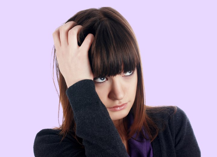 Woman scratching her irritated scalp