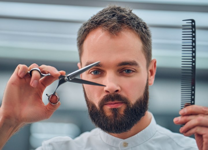 Barber holding comb and scissors