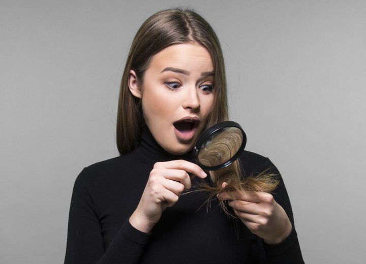 Girl checking her own hair for split ends