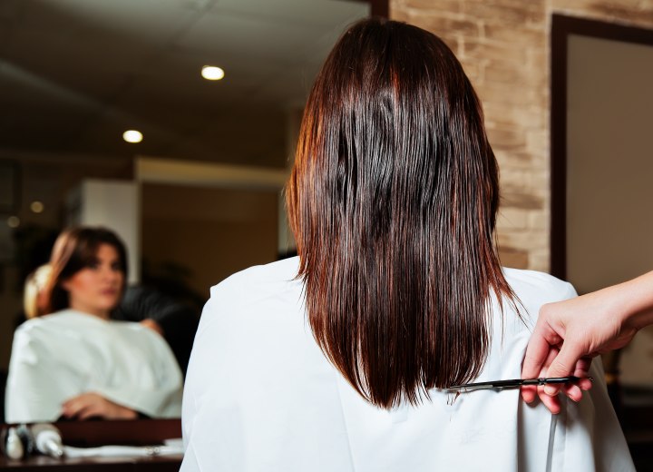 Hairdresser cutting long hair