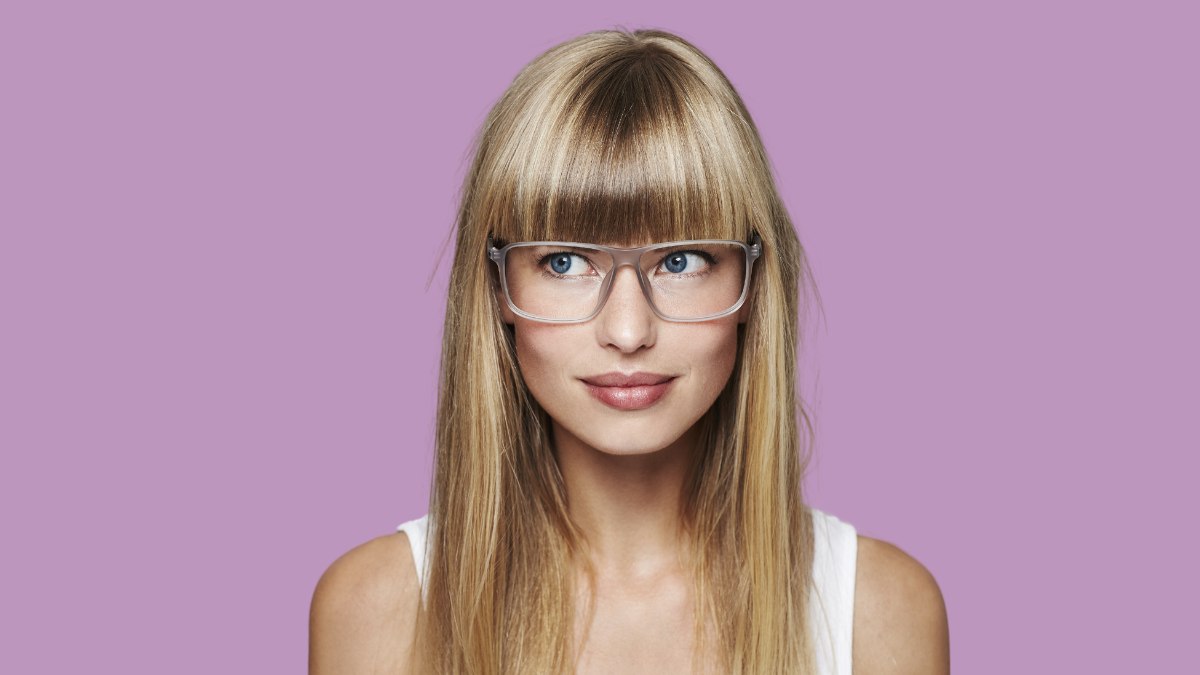 Wearing glasses and long blunt cut straight bangs or a fringe