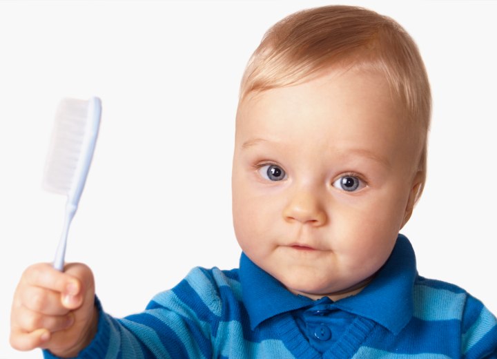 Infant trying to brush his hair