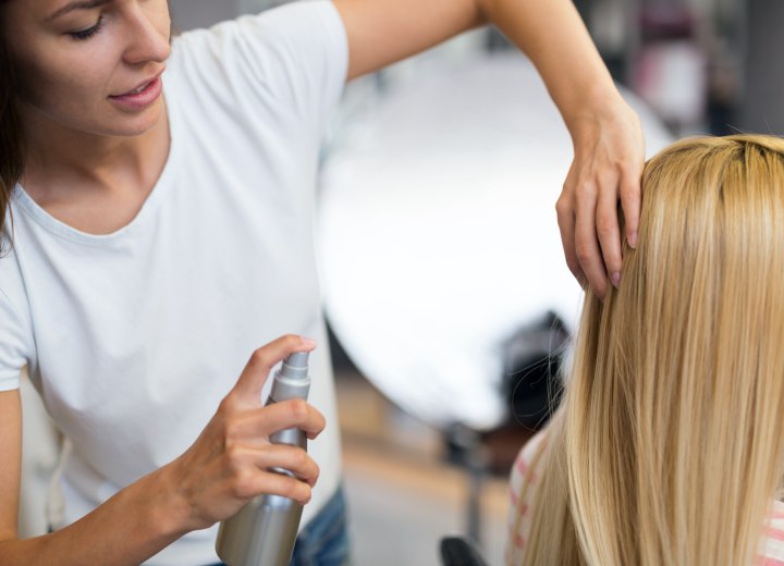 Spraying hair with a protectant spray