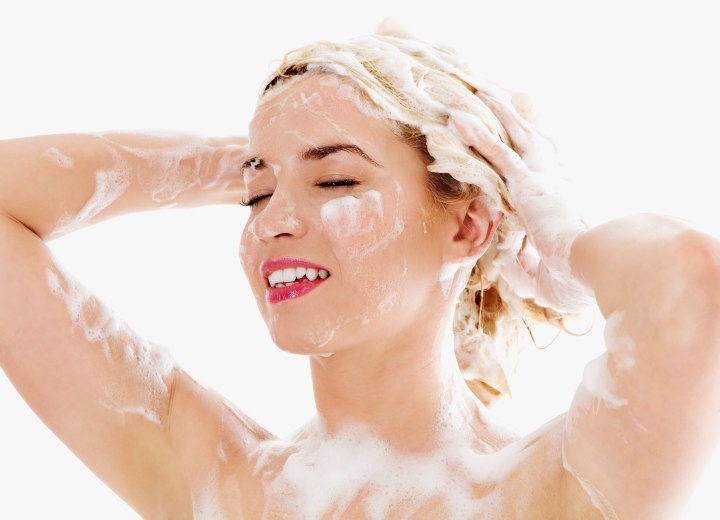 Woman washing her hair with too much shampoo